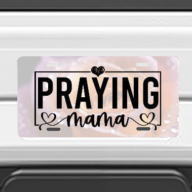 License plate with 'PRAYING mama' text on a reflective surface