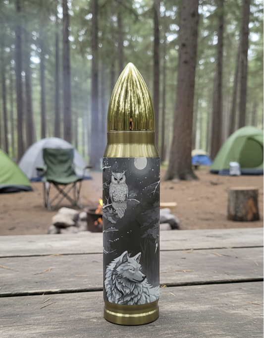 Bullet shaped tumbler with wolf design sitting on a wooden table in a forest setting