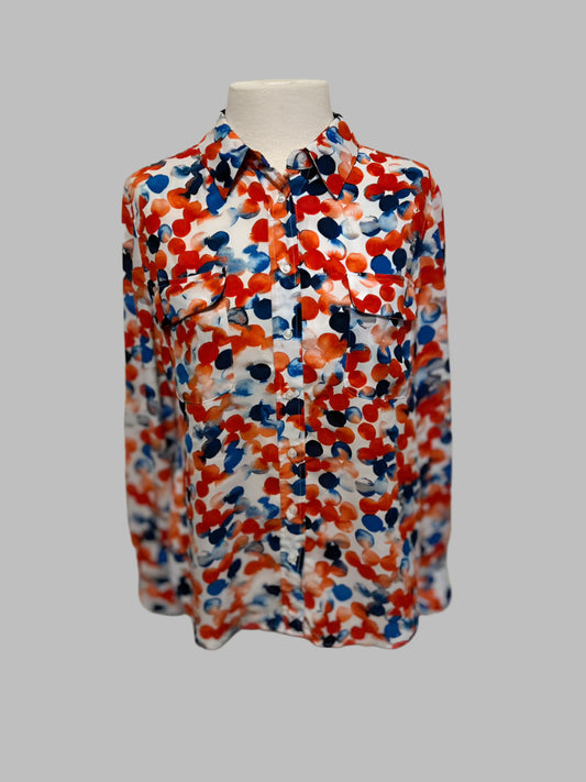 Colorful patterned shirt on a mannequin against a white door.