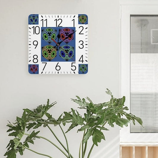 Colorful wall clock on a white wall above a potted plant in a room with a bookshelf and table.