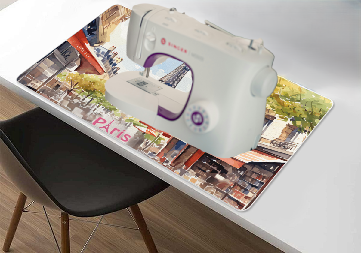 Sewing machine on a table with a Paris-themed desk mat.