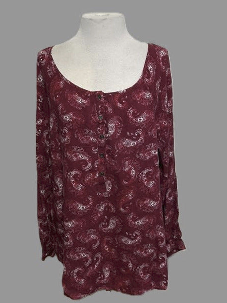 Maroon patterned top on a mannequin against a gray background