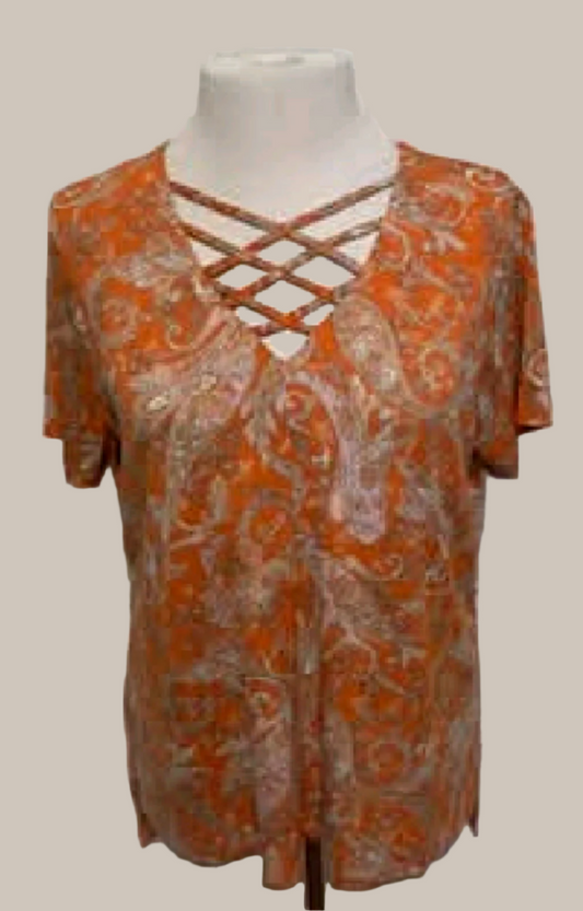 Orange patterned top on a mannequin against a white background