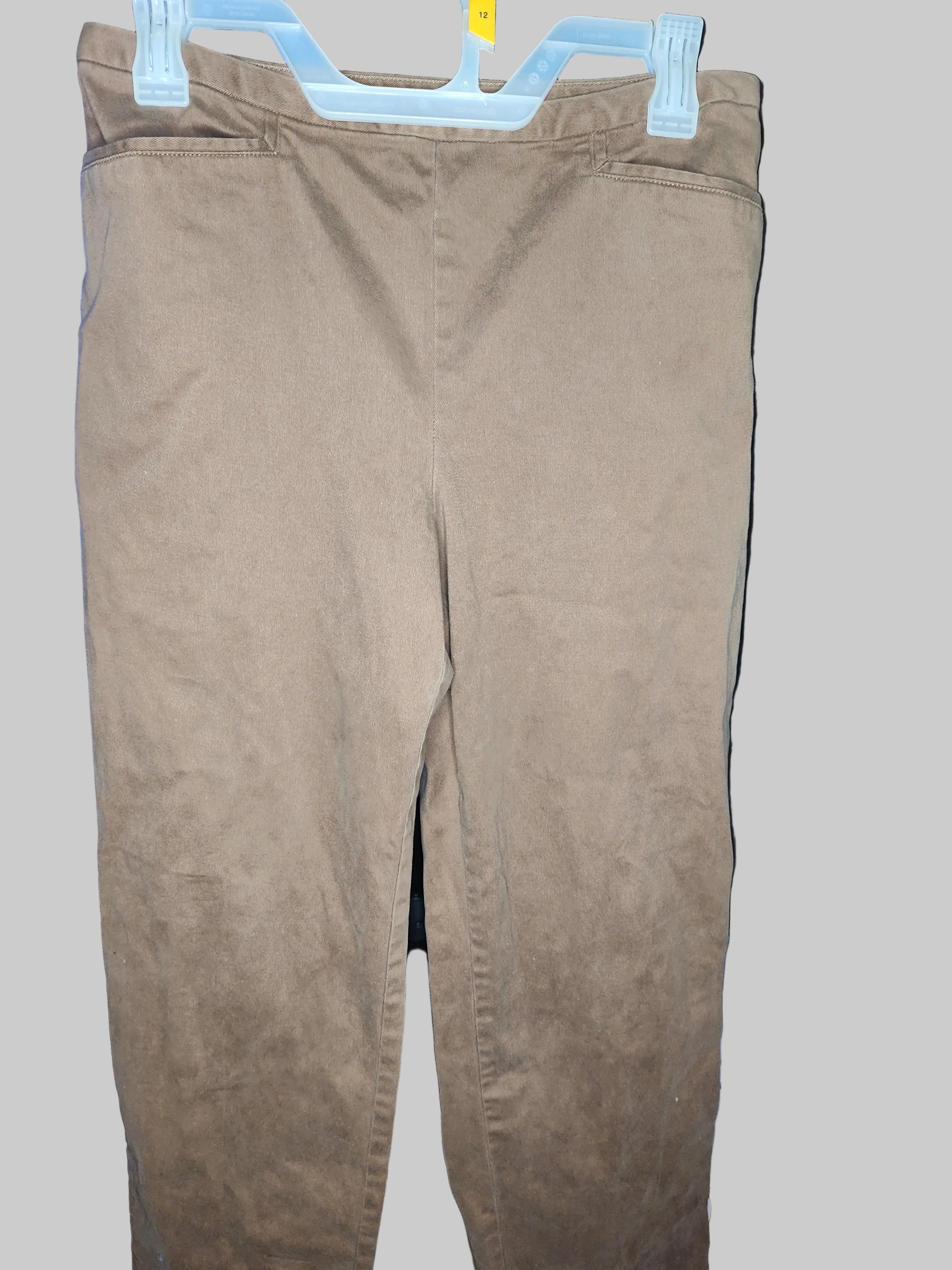 Brown pants hanging on a blue hanger against a gray background