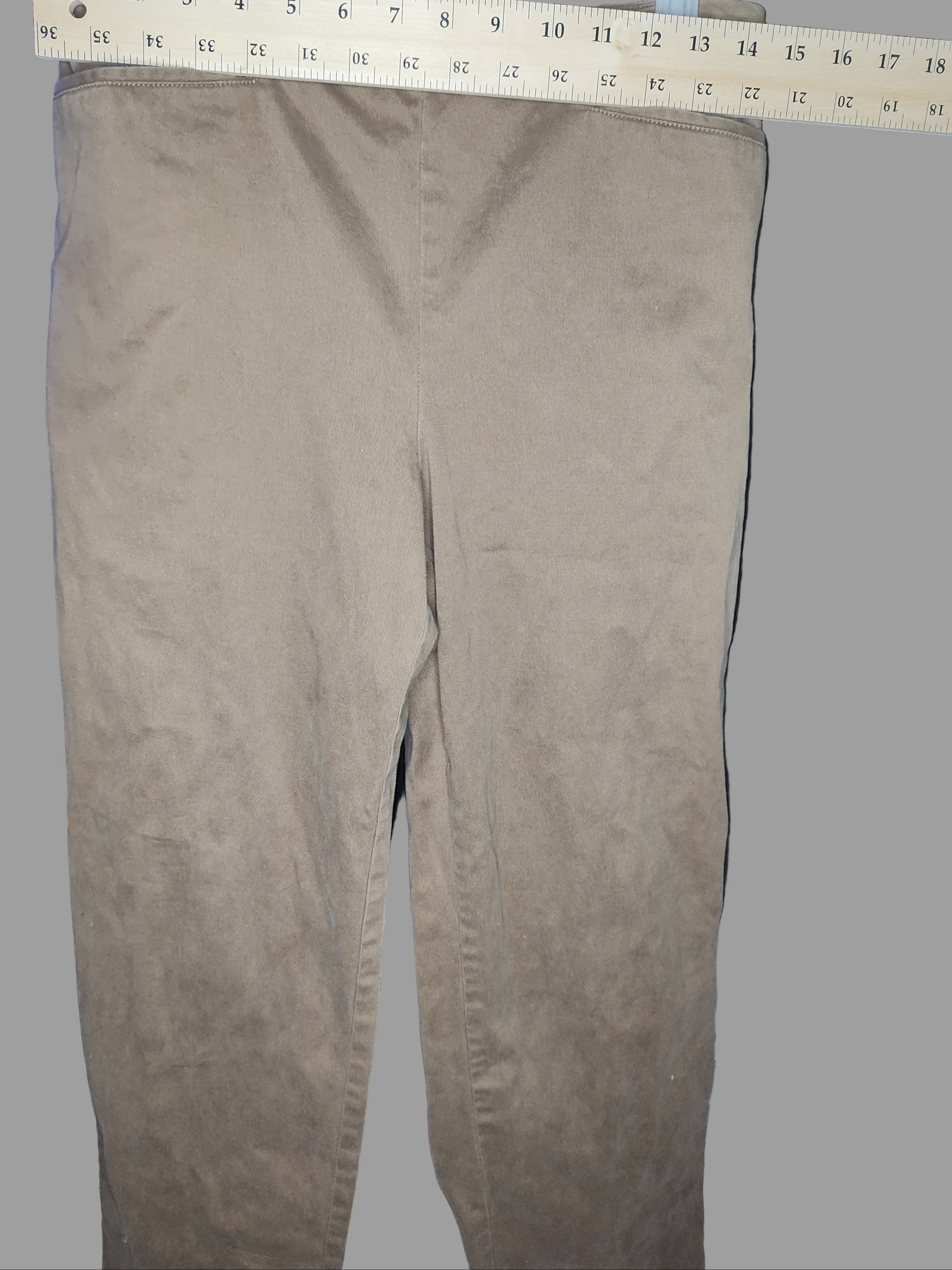 Brown pants with a ruler for scale on a dark background