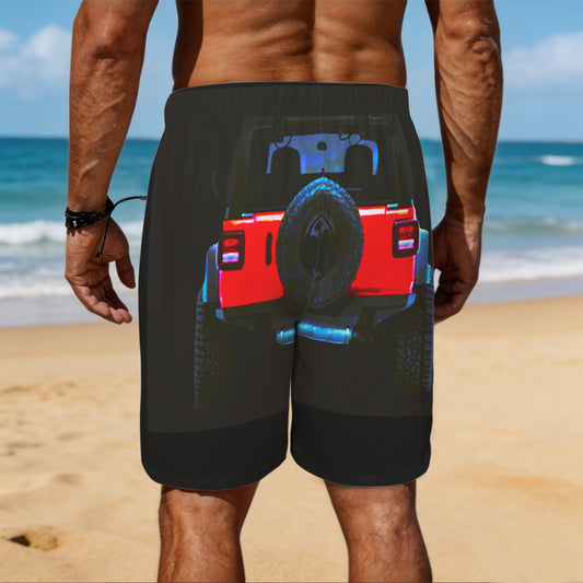 Person wearing black shorts with a graphic design of a red truck on a beach.