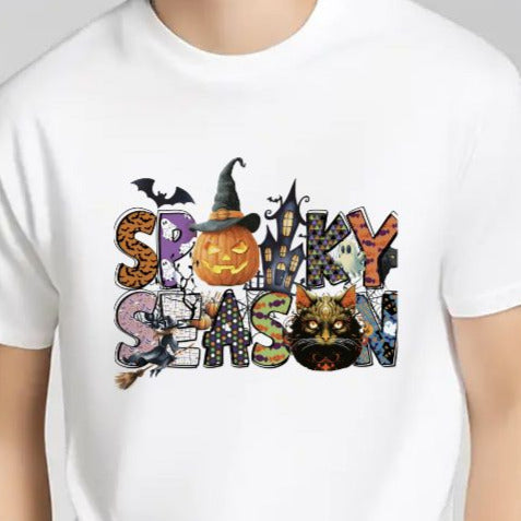 Person wearing a white t-shirt with Halloween-themed graphics on a gray background