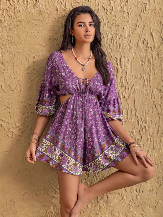 Woman wearing a purple floral dress against a textured beige wall